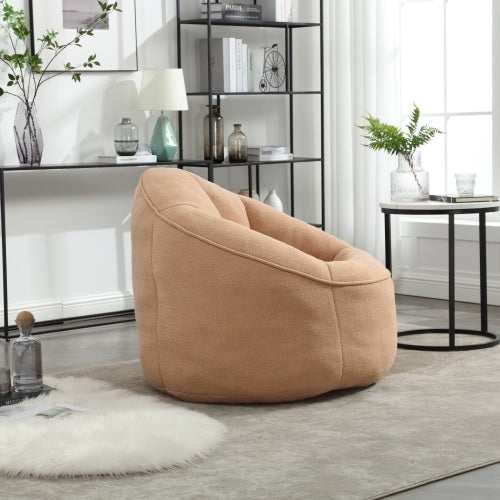 Side view of tan bean bag sofa chair with footrest, showing plush texture and design