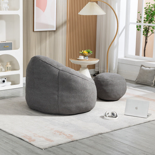 Side view of dark grey bean bag sofa chair with footrest, showing plush texture and design