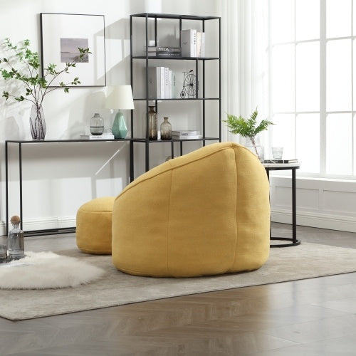 Back view of light yellow bean bag sofa chair with footrest, showing plush texture and design