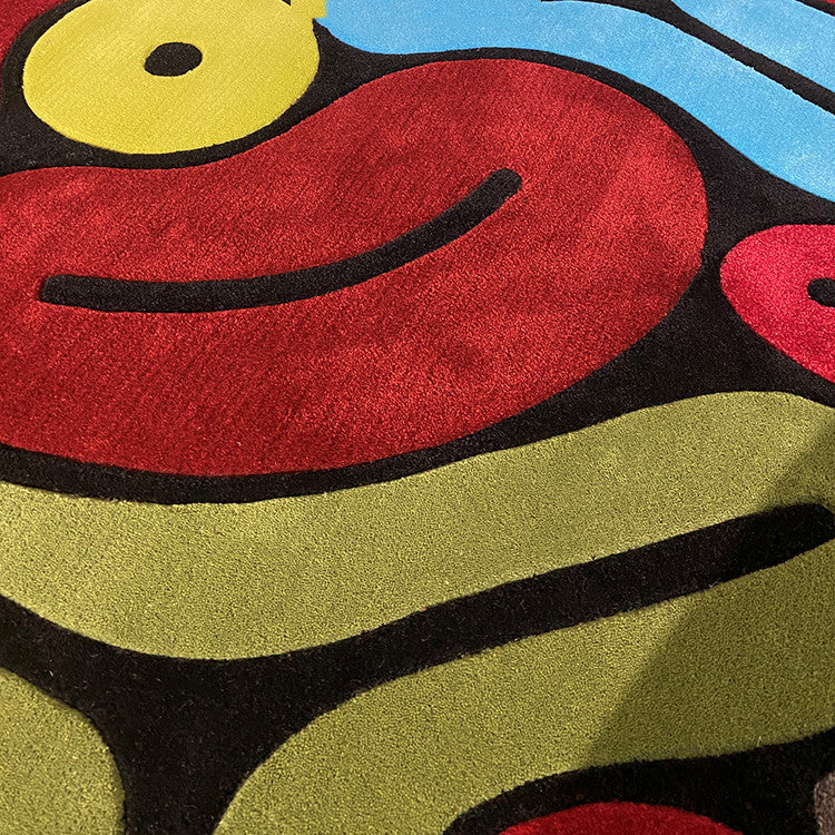 Close-up of a colorful abstract design with red, yellow, green, and blue shapes of handmade wool rug