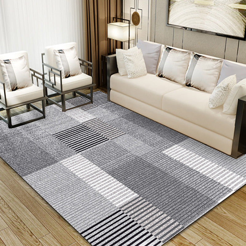 Living room with dark grey, light grey, white, and black vertical stripe rug, modern decor