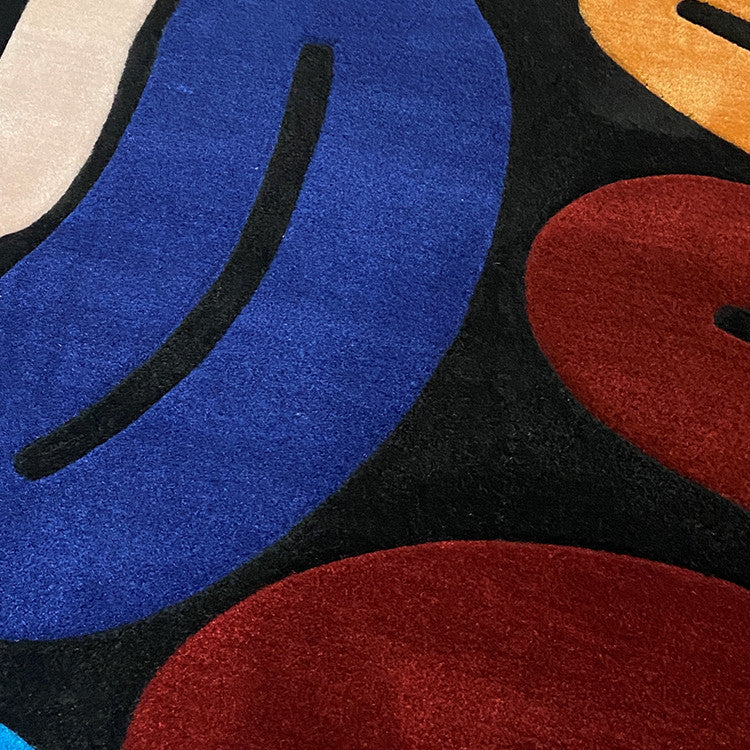Close-up of a colorful abstract rug with blue, red, and black shapes of handmade wool rug