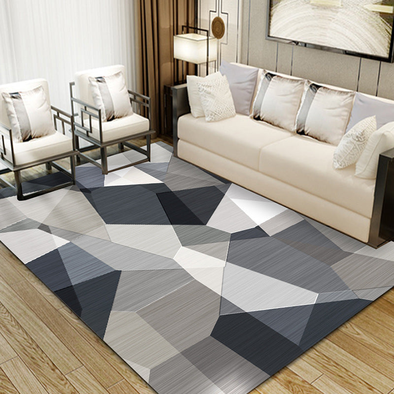 Living room with dark blue, black, light brown, grey, and white irregular geometric rug, modern decor